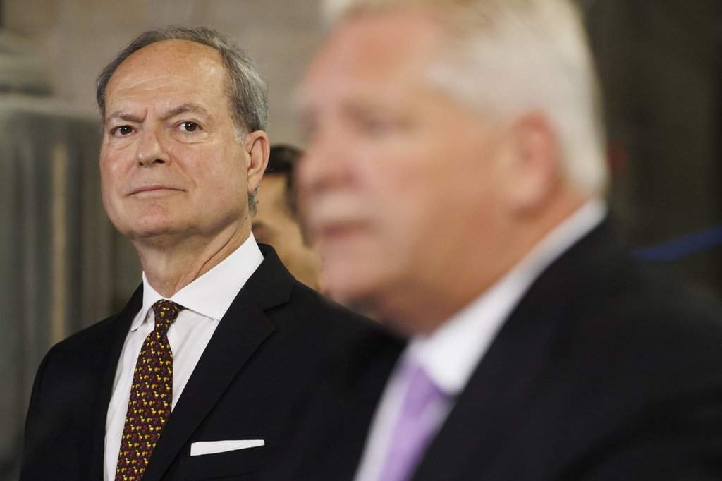 Ontario Finance Minister Peter Bethlenfalvy watches as Ontario Premier Doug Ford speaks to media at a press conference at the Cool Beer Brewing Company in Toronto, on Wednesday, July 10, 2024. 