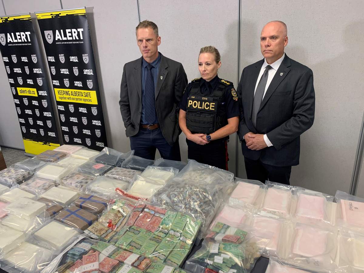 Members of the Alberta Law Enforcement Response Teams show off some of millions of dollars worth of drugs and cash that were seized during an investigation spanning several Alberta communities.