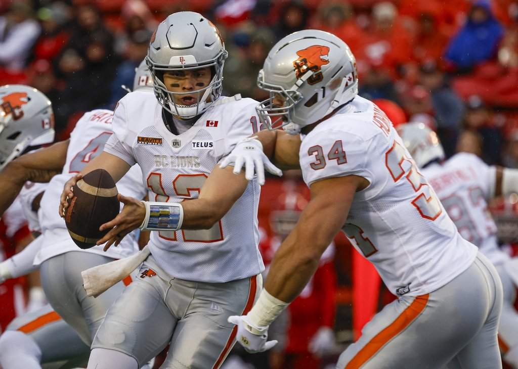 B.C. Lions quarterback Nathan Rourke, left, hands off to Zander Horvath against the Stampeders in Calgary on Thursday, Aug. 13, 2026. THE CANADIAN PRESS/Jeff McIntosh.