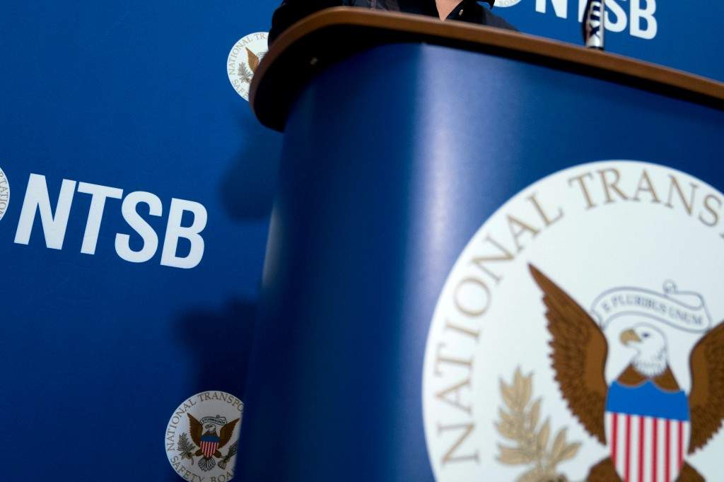 The National Transportation Safety Board logo and signage are seen at a news conference at NTSB headquarters in Washington.