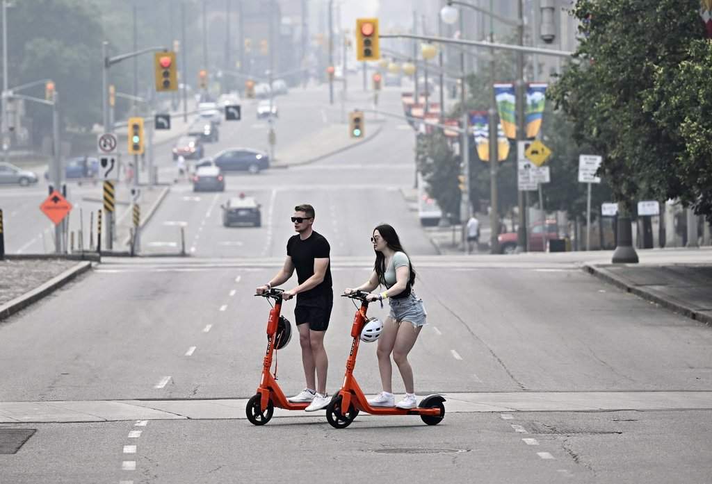 People ride e-scooters in this file photo. THE CANADIAN PRESS/Justin Tang.