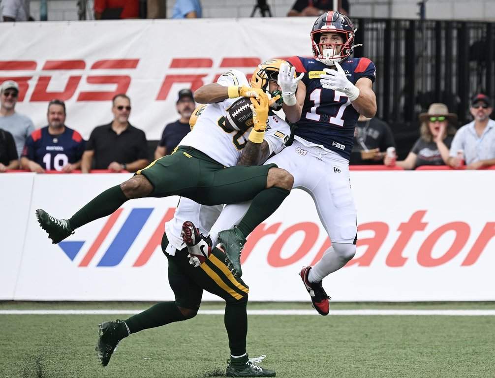 Edmonton Elks' Tyrell Ford, left, intercepts the ball ahead of Montreal Alouettes' Cole Spieker (17) during first half CFL football action in Montreal, on Saturday, Aug. 8, 2026. THE CANADIAN PRESS/Graham Hughes.