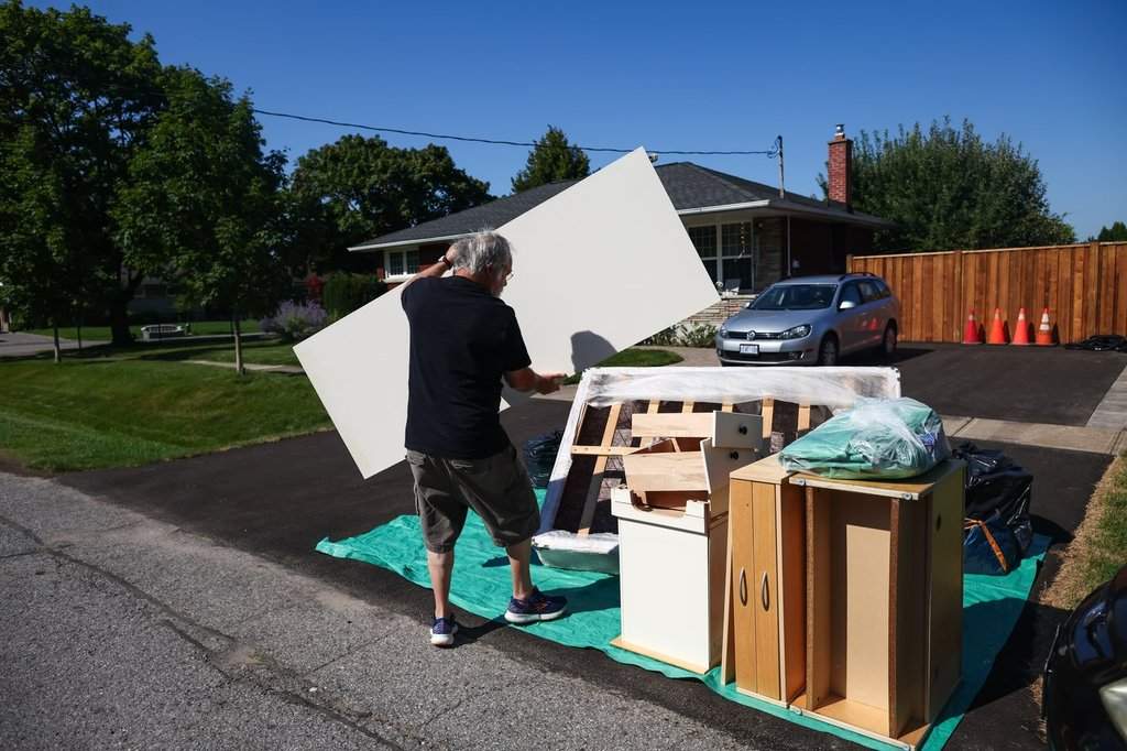 A resident piles belongings cleared out from his flooded house in St. Catharines' north end neighbourhood following flash floods from heavy rainfall in the area, Wednesday, August 5, 2026. 