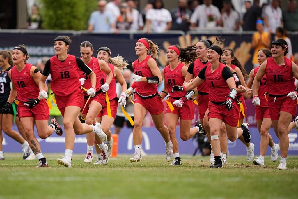 Canada's players celebrate and run to their injured teammate after winning the Flag Football World Championship women's final game between Canada and USA in Duesseldorf, Germany, Sunday, Aug. 16, 2026. 