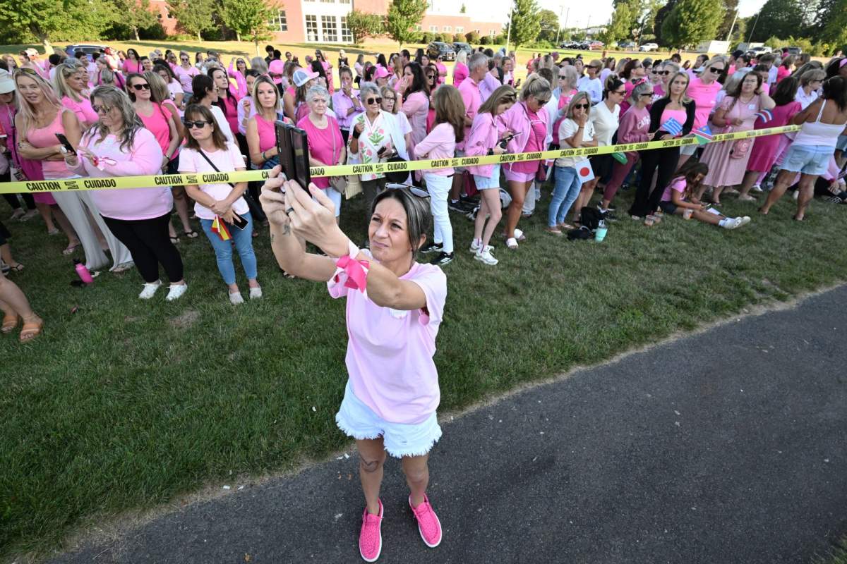 FILE- Aimee Breault of Acushnet, Mass., live-streams a demonstration in support of Lindsay Clancy outside Plymouth Superior Court, where Clancy is on trial in connection with the deaths of her three children, Thursday, Aug. 20, 2026, in Plymouth, Mass.  