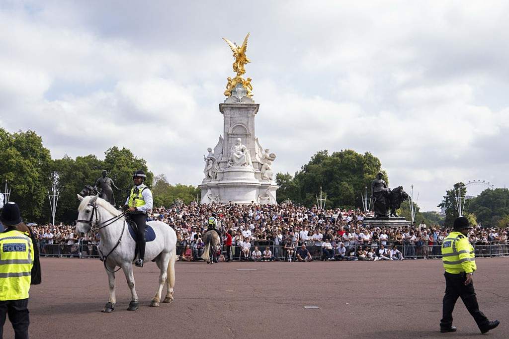 Spectators on the QVM watch members of the band of the Coldstream Guards and Welsh Guards play a tribute to singer Dolly Parton during the Changing the Guard at Buckingham Palace, London.