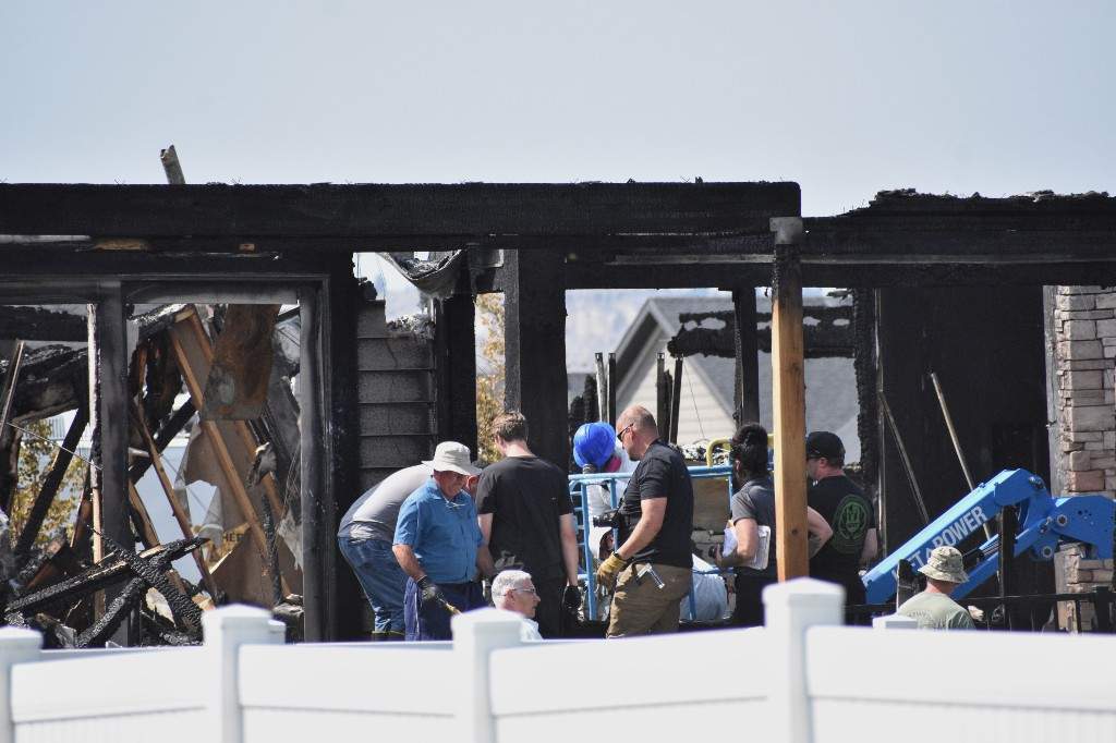 Investigators work at the scene Tuesday, Aug. 25, 2026, where a family was killed and the house burned in Billings, Mont.