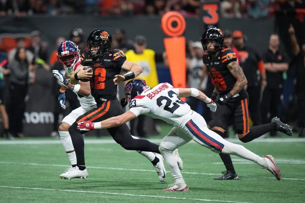 B.C. Lions quarterback Nathan Rourke (12) runs the ball for a first down past Montreal Alouettes' Nate Beauchemin (23) during the first half of a CFL game, in Vancouver, on Saturday, Sept. 12, 2026. THE CANADIAN PRESS/Darryl Dyck.