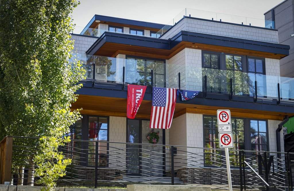 An American flag and Trump flags adorn a house in Calgary, Monday, Aug. 31, 2026. 