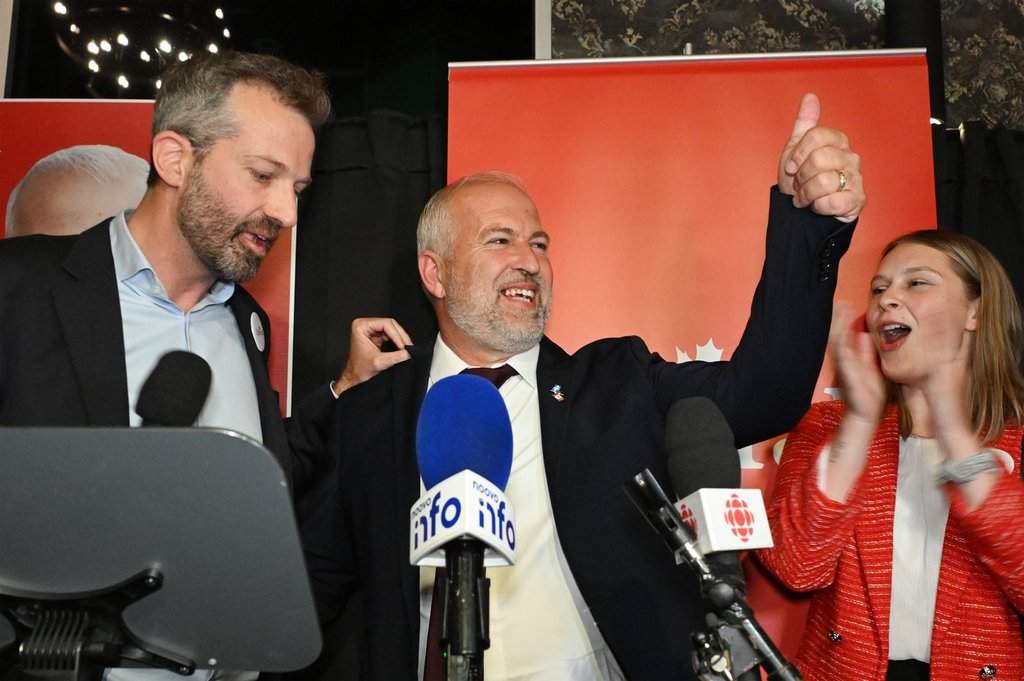Liberal MP-elect Daniel Gobeil, centre, reacts to winning a byelection in the federal riding of Chicoutimi-Le Fjord in Saguenay, Que., on Monday, Aug. 31, 2026. Joel Lightbound, left, minister of Government Transformation, Public Works and Procurement, and Gobeil’s daughter Marianne Gobeil, right, look on. THE CANADIAN PRESS/Jacques Boissinot