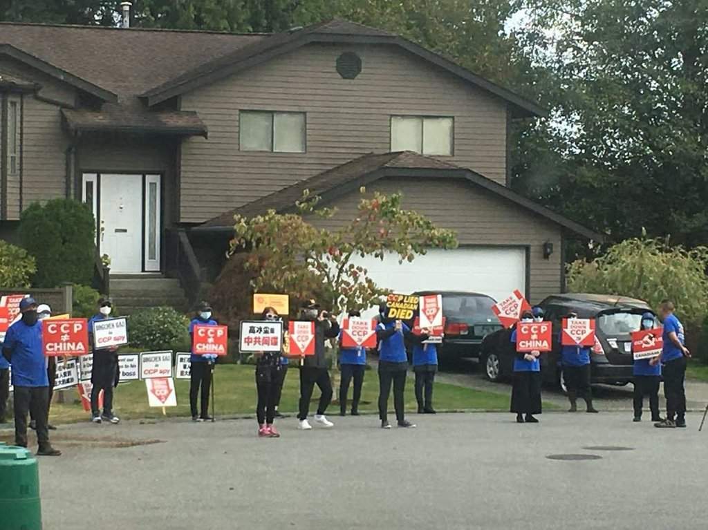 A group of protesters hold up signs outside Gao Bing Chen's home in Surrey, B.C., in a 2020 handout photo. Gao has been awarded $275,000 in defamation damages from a man who livestreamed the protests, which a judge says made baseless claims about Gao. THE CANADIAN PRESS/Handout - Gao Bing Chen (Mandatory Credit).
