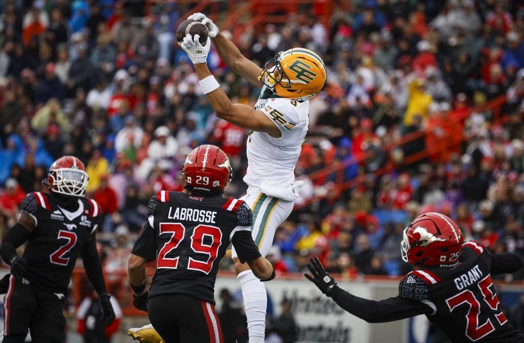Edmonton Elks' Austin Mack, centre, brings down a pass as Calgary Stampeders' Kyle Wilson, left, Ben Labrosse, centre left, and Jaydon Grant look on during first half CFL action in Calgary, Monday, Sept. 7, 2026. THE CANADIAN PRESS/Jeff McIntosh.
