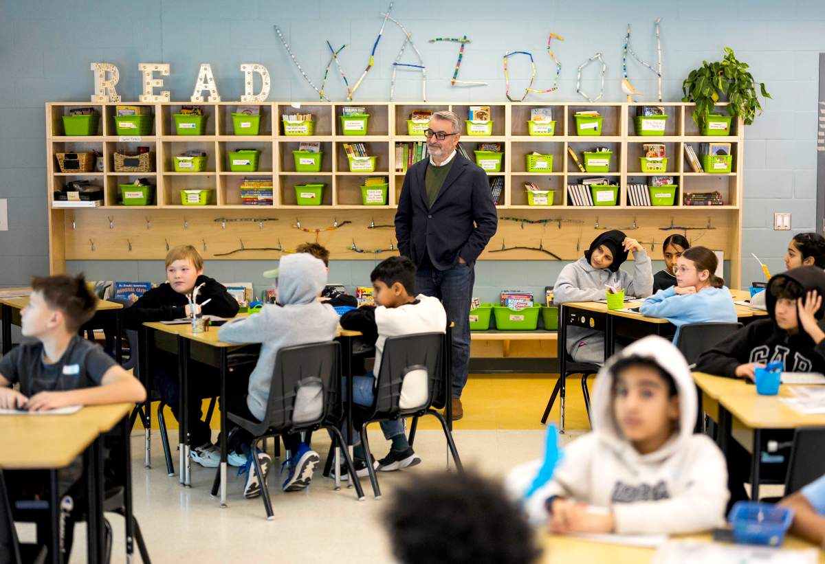 Ontario Education Minister Paul Calandra listens in on a grade 6 math class as he tours Wazoson Public School after making a funding announcement in Ottawa, on Friday, Dec. 5, 2025.  