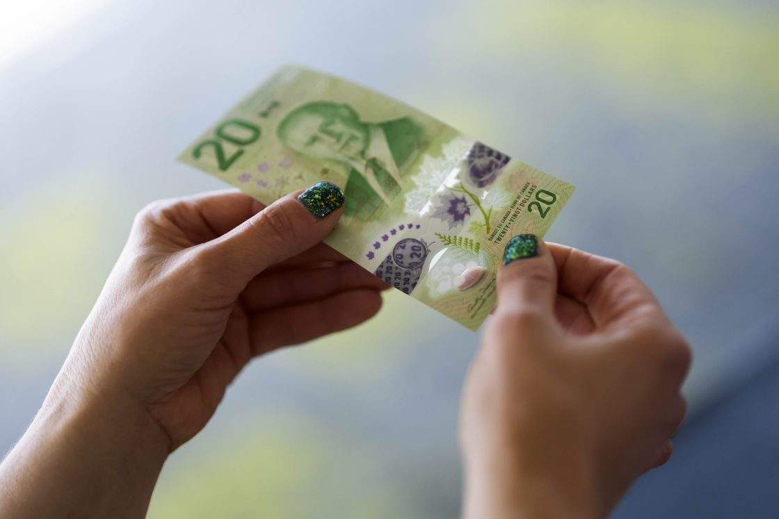 FILE - Holographic security features, shown in purple, are shown on the new Canadian $20 note featuring a portrait of King Charles III, at its unveiling event in Ottawa, on Thursday, Sept. 3, 2026.