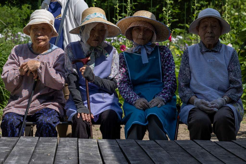 Senior residents of Sayo, Japan, gather while attending to maintain the iris flower field in Grandpa and Grandma's Flower Garden on June 13, 2024.