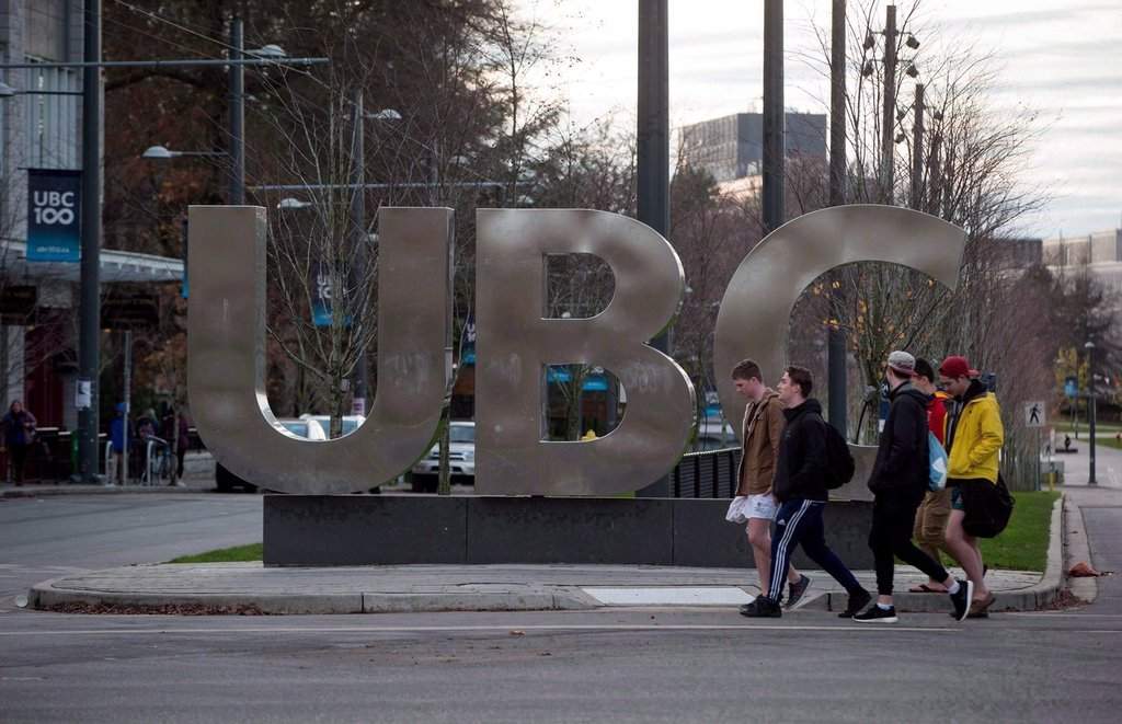 People walk past large letters spelling out UBC at the University of British Columbia in Vancouver on Nov. 22, 2015. 