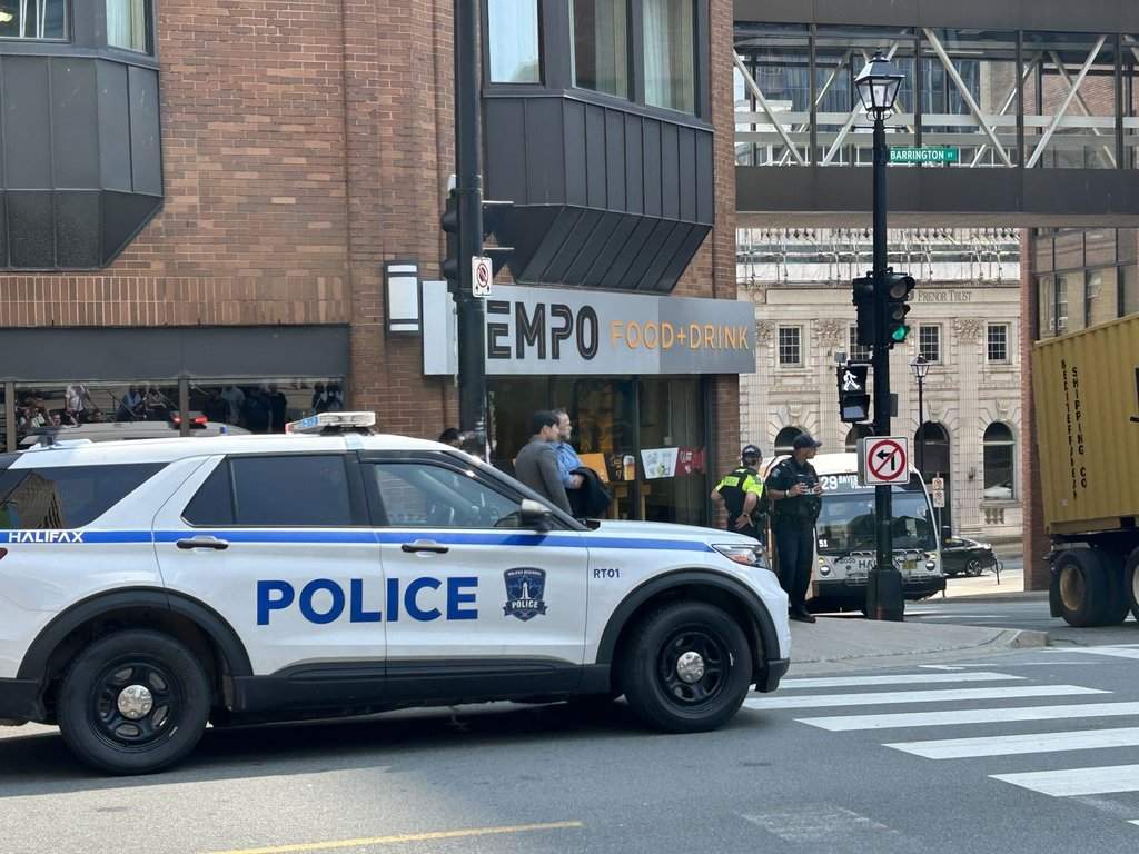 Responding to a bomb threat, police direct people to evacuate at the intersection of Barrington Street and Duke Street, in downtown Halifax, on Monday, Aug. 10, 2026. THE CANADIAN PRESS/Devin Stevens.