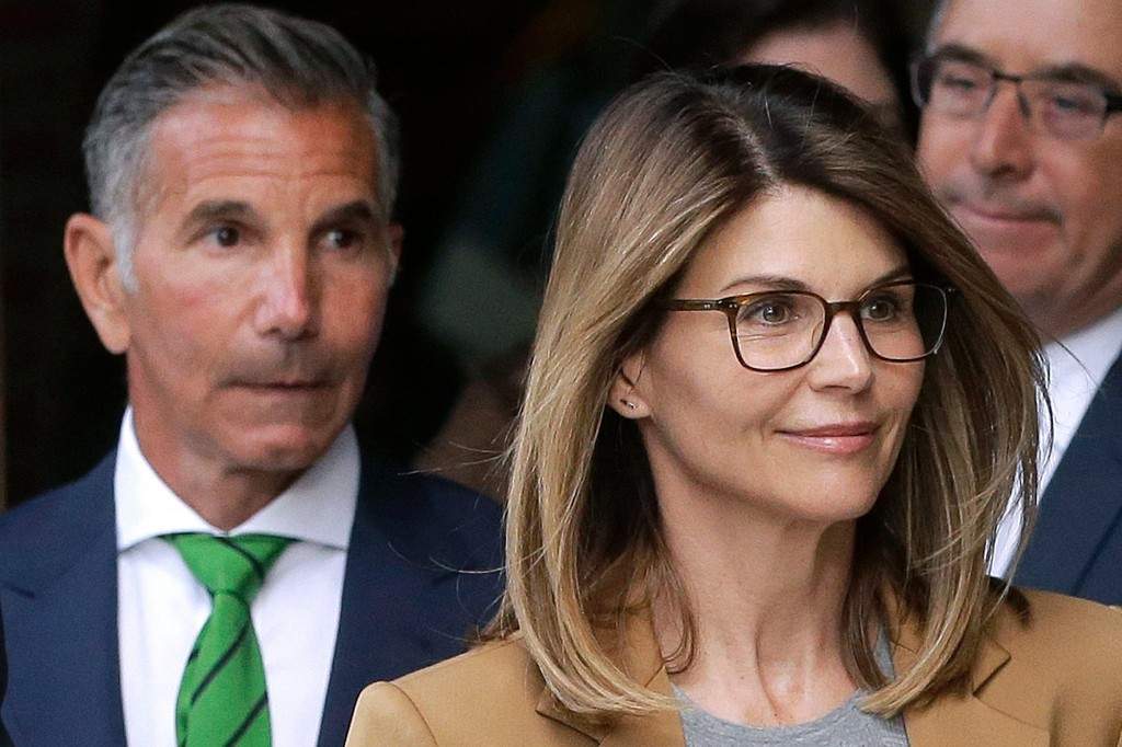 Actress Lori Loughlin, front, and clothing designer Mossimo Giannulli, left, depart federal court in Boston on Wednesday, April 3, 2019, after facing charges in a nationwide college admissions bribery scandal.