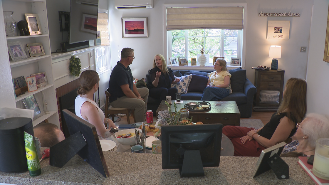 Global News reporter Mike Armstrong sits and listens to four members of Michael J. Armstrong's family.