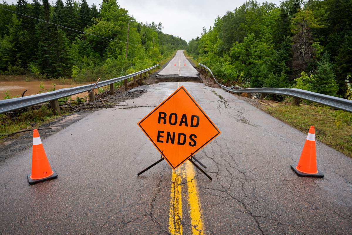 Warning signage is seen in front of a washed out road near Marble Mountain, in Cape Breton, N.S., Saturday, Sept. 5, 2026.