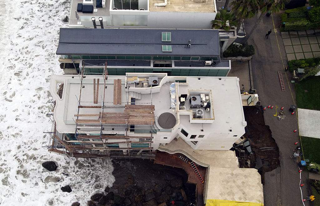 This aerial view shows a sinkhole on a street and driveway of a seaside home affected by large swells produced by Hurricane Marie in Malibu, California, on September 8, 2026.