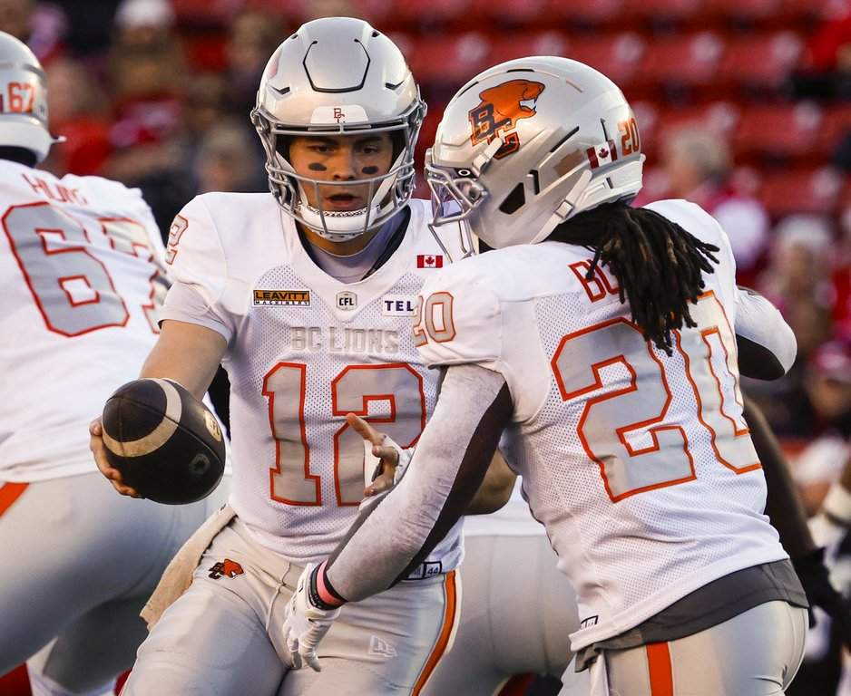 B.C. Lions quarterback Nathan Rourke, left, hands the football off to James Butler during first half CFL action against the Calgary Stampeders in Calgary, Saturday, Oct. 17, 2026. THE CANADIAN PRESS/Jeff McIntosh.
