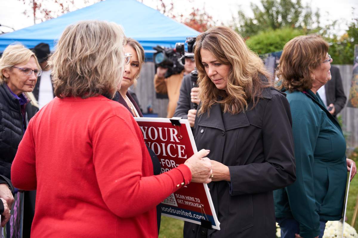 Premier Danielle Smith andJaclyn Soroka, co-founder of Edmonton Neighbourhoods United, speak with supporters after announcing the province has ordered the city to roll back bylaws allowing more infill on Oct. 8, 2026.