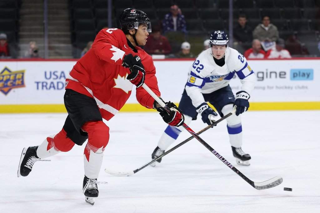 Canada defenseman Kashawn Aitcheson (2) controls the puck against Finland forward Emil Hemming (22) during the first period of an IIHF World Junior Hockey Championship bronze medal game, Monday, Jan. 5, 2026, in St. Paul, Minn. (AP Photo/Matt Krohn).
