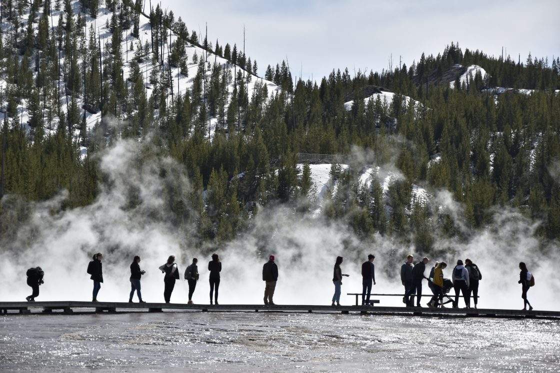 FILE - Visitors are seen at Grand Prismatic Spring in Yellowstone National Park, Wyo. on May 1, 2021.