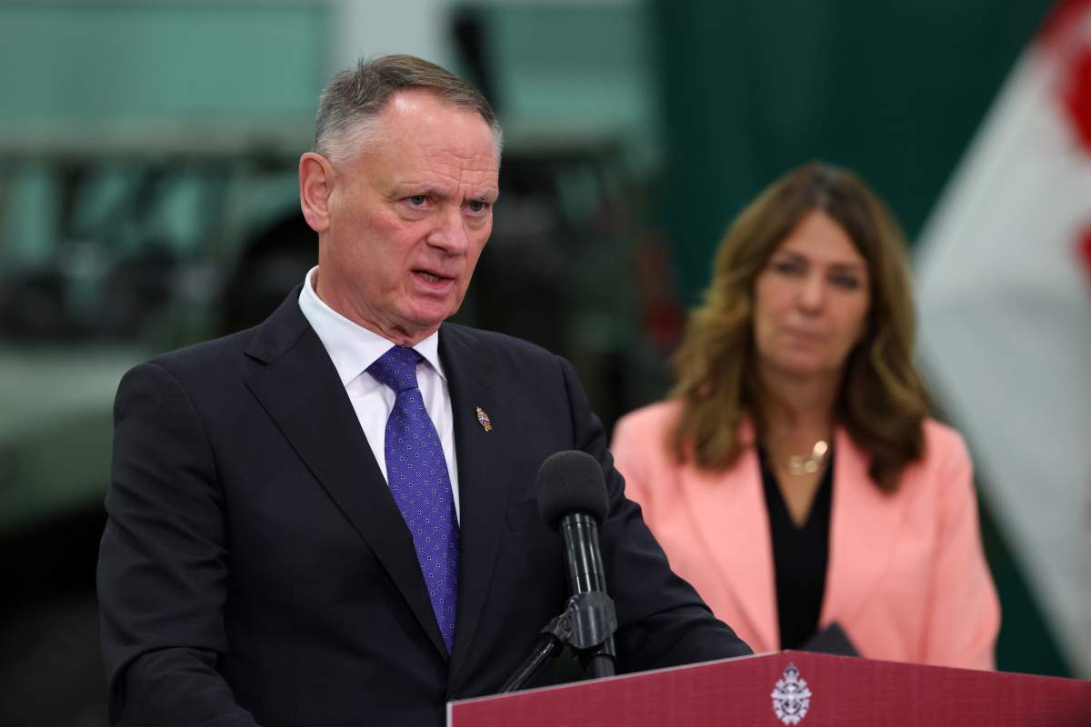 National Defence Minister David McGuinty answers questions as Alberta Premier Danielle Smith looks during a press conference at the Canadian Forces Base in Edmonton on Wednesday, Oct. 7, 2026. 