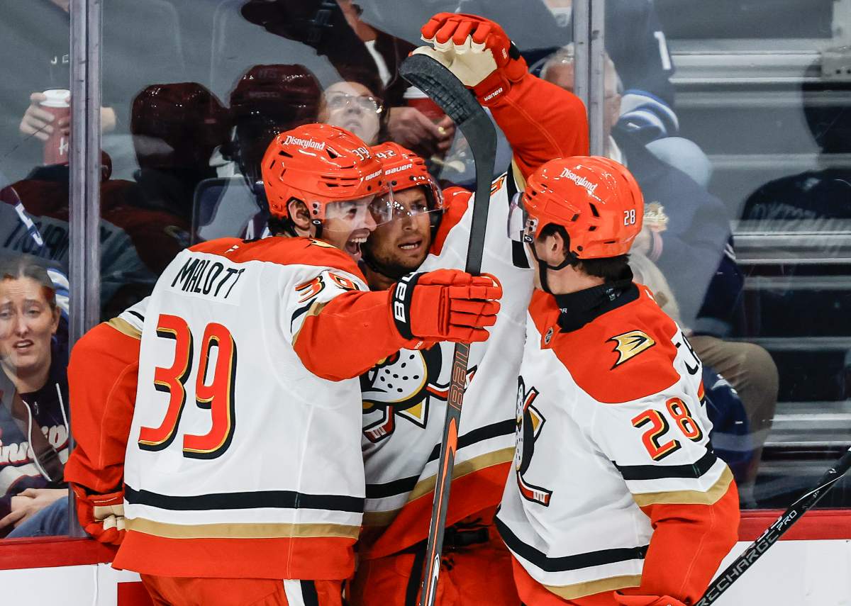 Anaheim Ducks' Jeff Malott (39), Tim Washe (42) and Judd Caulfield (28) celebrate Washe's goal against the Winnipeg Jets during second period NHL hockey action in Winnipeg on Friday, October 9, 2026. THE CANADIAN PRESS/John Woods.