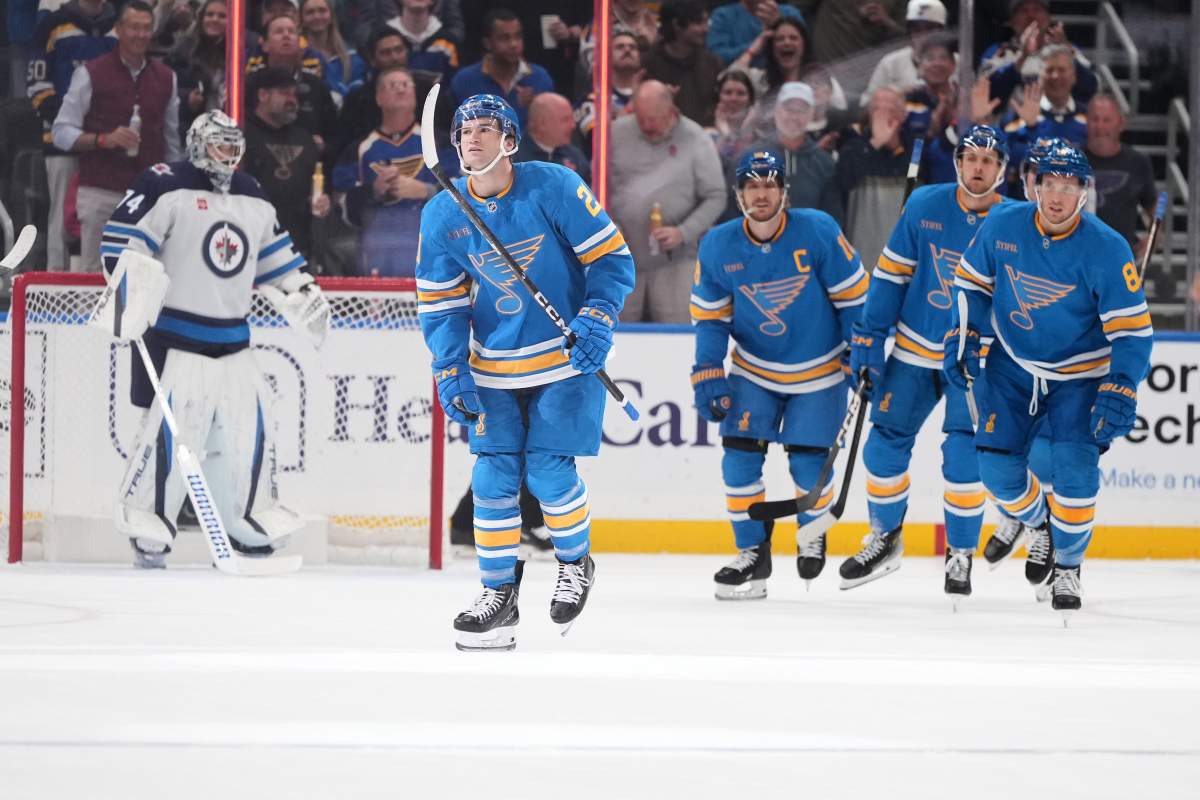 St. Louis Blues' Jimmy Snuggerud, second from left, skates off the ice after scoring past Winnipeg Jets goaltender Stuart Skinner (74) during the first period of an NHL hockey game Tuesday, Oct. 20, 2026, in St. Louis. (AP Photo/Jeff Roberson).