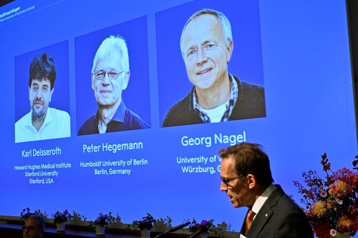 Karl Deisseroth, Peter Hegemann and Georg Nagel are shown on the screen as they are awarded the 2026 Nobel Prize in Physiology or Medicine, as announced during a press conference at the Nobel Forum at Karolinska Institutet in Stockholm, Sweden, Oct. 5, 2026. (Pontus Lundahl/TT News Agency via AP)