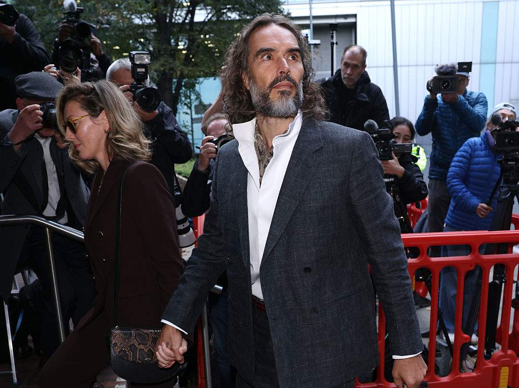 Russell Brand, accompanied by wife Laura Brand arrives at court ahead of his trial, where he faces rape and sexual assault charges at Southwark Crown Court on October 12, 2026.