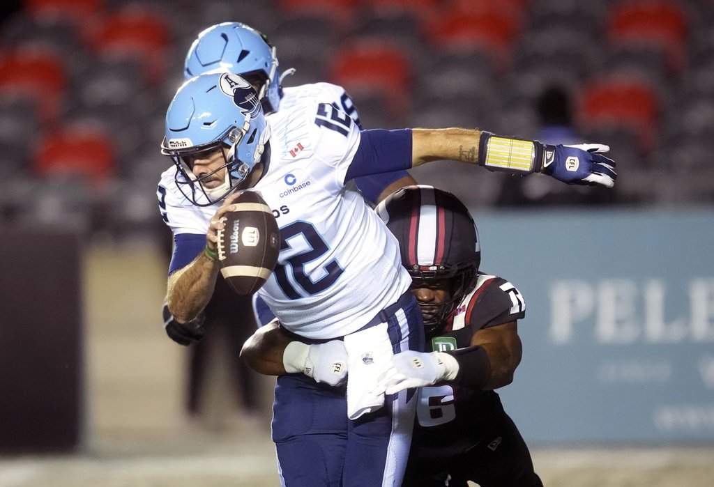 Toronto Argonauts quarterback Chad Kelly (12) is sacked by Ottawa Redblacks linebacker Aaron Casey (36) during first half CFL action in Ottawa, Friday, Oct. 16, 2026. THE CANADIAN PRESS/Adrian Wyld.