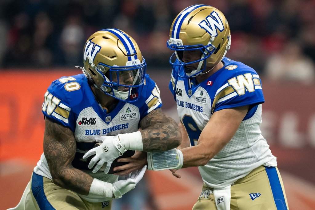 Winnipeg Blue Bombers quarterback Zach Collaros (8) hands the ball to Brady Oliveira (20) during the first half of a CFL football game, in Vancouver, on Friday, Oct. 23, 2026. THE CANADIAN PRESS/Ethan Cairns.