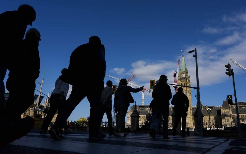 People cross Wellington Street on their way to Parliament Hill, a day before the return of the House of Commons, on Sunday, Sept. 14, 2025. 