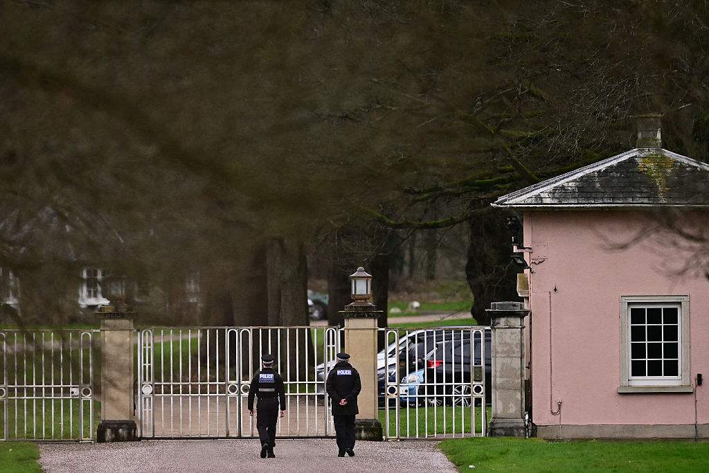 Police officers walk towards the entrance to Royal Lodge, a 30-room property and former residence to Britain's former prince Andrew where police said they are still conducting a search, in Windsor, west of London on February 20, 2026.