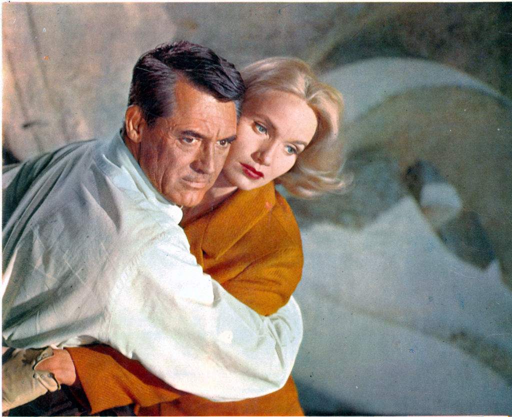 Cary Grant holding Eva Marie Saint in a scene from the film 'North By Northwest', 1959. Grant is wearing a pale grey Oxford shirt by Brooks Brothers.