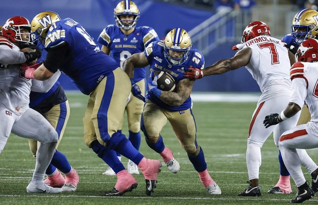 Winnipeg Blue Bombers' Brady Oliveira (20) runs for the first down against the Calgary Stampeders during second half CFL football action in Winnipeg on Saturday, Oct. 10, 2026. THE CANADIAN PRESS/John Woods.