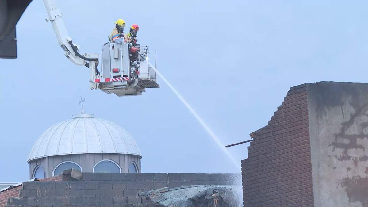 Firefighters work to put out hot spots in a building that was ablaze early Wednesday morning on Oct. 7 in Montreal's Park-Extension neighbourhood.