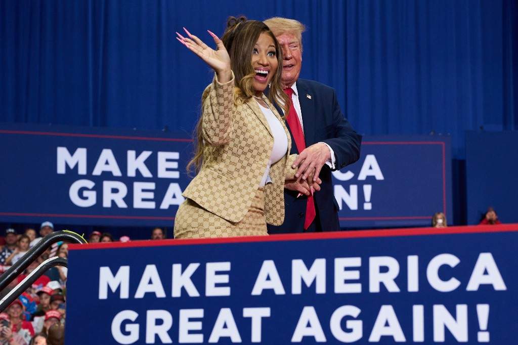 U.S. President Donald Trump helps Nicki Minaj to the stage during a campaign rally at McMorran Place Sports and Entertainment Center, Sunday, Oct. 25, 2026, in Port Huron, Mich.