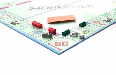 Monopoly board with houses and tokens near GO—showing how Monopoly relates to real life money and strategy.